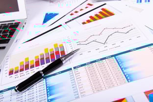 Financial paper charts and graphs on the table Financial paper charts and graphs on the table
