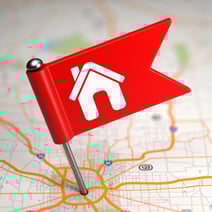 Red Small Flag with House Icon on a Map Background with Selective Focus.
